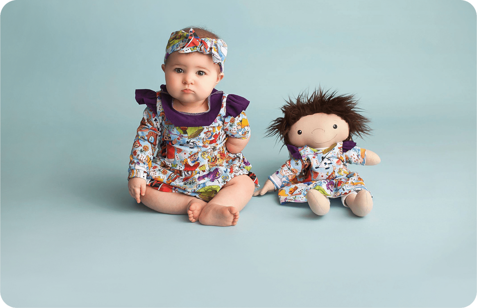Baby girl with a similar looking doll on her side